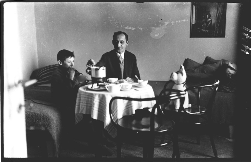 Husband and son (and teddy-bear) at table.